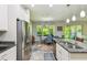 Open-concept kitchen features stainless steel appliances, granite countertops, white cabinets and a dining area with natural light at 582 San Joaquin Rd, Poinciana, FL 34759