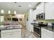 Modern kitchen with granite countertops, stainless steel appliances, and an open view of the living area at 582 San Joaquin Rd, Poinciana, FL 34759
