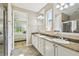 Bright main bathroom with dual vanities, tile flooring, a glass-enclosed shower, and views of the bedroom at 582 San Joaquin Rd, Poinciana, FL 34759