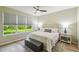 Serene main bedroom with a king-size bed, natural light, wood flooring, and views of the greenery outside at 582 San Joaquin Rd, Poinciana, FL 34759