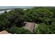Aerial view showcasing a home's roof surrounded by lush mature trees and lake views at 860 Oak Shore Dr, St Cloud, FL 34771