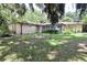 Backyard showcasing lawn, mature trees and the exterior of the home at 860 Oak Shore Dr, St Cloud, FL 34771
