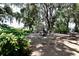 Landscaped backyard featuring mature trees, shrubs and outdoor seating area at 860 Oak Shore Dr, St Cloud, FL 34771