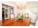 Formal dining room with a large wooden table, decorative chandelier, and elegant window treatments at 860 Oak Shore Dr, St Cloud, FL 34771