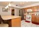 Bright kitchen featuring an island counter with bar stools, stainless steel refrigerator, and wood cabinetry at 860 Oak Shore Dr, St Cloud, FL 34771