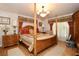 Spacious main bedroom features a four-poster bed, hardwood floors, and decorative lighting at 860 Oak Shore Dr, St Cloud, FL 34771