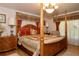 Spacious main bedroom features a four-poster bed, hardwood floors, and decorative lighting at 860 Oak Shore Dr, St Cloud, FL 34771