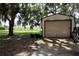 Exterior of a shed with a roll-up door in a grassy yard at 860 Oak Shore Dr, St Cloud, FL 34771