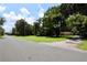 Street view with expansive green lot and a charming home nestled under mature trees at 860 Oak Shore Dr, St Cloud, FL 34771