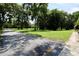 Paved driveway leading to a large, green front yard with mature trees at 860 Oak Shore Dr, St Cloud, FL 34771