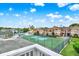 View from the deck highlighting the community pool, tennis courts, and building exteriors at 8716 Rain Forest Pl # D, Kissimmee, FL 34747