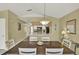 Open dining area with wood table and view into kitchen with breakfast bar at 8716 Rain Forest Pl # D, Kissimmee, FL 34747