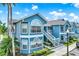 Condo exterior showcasing the detailed architectural trim, private stairway, and lush landscaping at 8716 Rain Forest Pl # D, Kissimmee, FL 34747