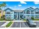 Exterior shot of condo buildings with beautiful windows, a parking area, and well-maintained landscaping at 8716 Rain Forest Pl # D, Kissimmee, FL 34747
