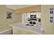 Well-lit kitchen with white cabinets, breakfast bar, and view into adjoining spaces at 8716 Rain Forest Pl # D, Kissimmee, FL 34747