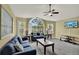 Bright living room features large window, ceiling fan, and two blue sofas with decorative pillows at 8716 Rain Forest Pl # D, Kissimmee, FL 34747