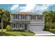 Charming two-story home boasts a manicured lawn, gray siding, and a convenient two-car garage at 1022 Wisteria Way, Dundee, FL 33838