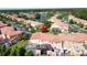 Aerial view of a residential area with colorful homes, a nearby lake and mature trees in a well-maintained community at 109 Pompano Beach Dr, Kissimmee, FL 34746
