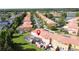 Aerial view of a well-maintained neighborhood with colorful townhouses and mature trees near a tranquil lake at 109 Pompano Beach Dr, Kissimmee, FL 34746