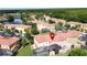 Aerial view of a residential community featuring manicured lawns, mature trees, and a picturesque lake with homes with screened patios at 109 Pompano Beach Dr, Kissimmee, FL 34746