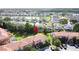 Aerial view of a neighborhood with colorful townhomes near a lake and lush green trees at 109 Pompano Beach Dr, Kissimmee, FL 34746