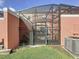 Enclosed backyard featuring a black metal gate, lawn, an air conditioner unit, and a partial view of screened pool area at 109 Pompano Beach Dr, Kissimmee, FL 34746