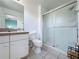 Bright bathroom featuring a tile floor, walk-in shower with glass doors, and neutral color palette at 109 Pompano Beach Dr, Kissimmee, FL 34746