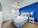 Comfortable bedroom features a queen size bed with blue accent wall, ceiling fan and a window at 109 Pompano Beach Dr, Kissimmee, FL 34746
