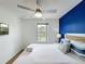 Airy bedroom showcases a queen bed with blue accent wall, flat screen tv and a window at 109 Pompano Beach Dr, Kissimmee, FL 34746