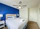 Bright bedroom boasts a queen bed, blue accent wall, and ample closet space at 109 Pompano Beach Dr, Kissimmee, FL 34746