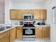 Well-equipped kitchen featuring a stainless steel microwave and stove, wooden cabinets, and plenty of counter space at 109 Pompano Beach Dr, Kissimmee, FL 34746