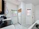 Compact kitchen featuring white appliances, tile flooring, and ample natural light from the windows at 109 Pompano Beach Dr, Kissimmee, FL 34746