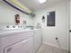 Bright laundry room featuring a white washer and dryer, shelving and fire extinguisher for added safety at 109 Pompano Beach Dr, Kissimmee, FL 34746
