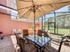 Inviting screened patio with a large dining table, brick pavers, and comfortable seating area for relaxing and entertaining at 109 Pompano Beach Dr, Kissimmee, FL 34746