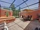 Screened patio features a dining table, outdoor seating, brick pavers and access to the backyard space at 109 Pompano Beach Dr, Kissimmee, FL 34746