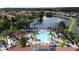 Aerial view of community pool, lake, and clubhouse surrounded by verdant landscaping at 109 Pompano Beach Dr, Kissimmee, FL 34746