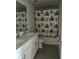 The bathroom features a double sink vanity and a fun, festive shower curtain at 1210 Zambrana Ct, Winter Haven, FL 33884