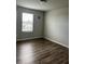 A cozy bedroom with ample natural light featuring wood-look flooring and a large window at 1210 Zambrana Ct, Winter Haven, FL 33884