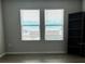 Well-lit room with two windows and wood-look flooring, complemented by a modern bookcase at 1210 Zambrana Ct, Winter Haven, FL 33884