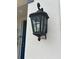 Exterior shot of a stylish outdoor light fixture with a lockbox on a stucco home at 1210 Zambrana Ct, Winter Haven, FL 33884
