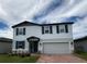 Charming two-story home with blue shutters, gray accents, and a red brick driveway at 1210 Zambrana Ct, Winter Haven, FL 33884