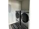 Modern laundry room featuring new, front-loading washer and dryer units at 1210 Zambrana Ct, Winter Haven, FL 33884
