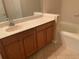Bathroom vanity with a light countertop, wood cabinets and a bathtub at 13620 Cepheus Dr, Orlando, FL 32828