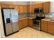Kitchen with stainless steel appliances, warm cabinets and tile backsplash at 13620 Cepheus Dr, Orlando, FL 32828