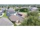 An aerial view of a residential neighborhood with mature trees, showcasing homes with screened-in pools and solar panels at 1364 Rebecca Dr, Haines City, FL 33844