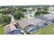Aerial view of homes with screened-in pools in a lush neighborhood near a golf course at 1364 Rebecca Dr, Haines City, FL 33844