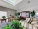 Relaxing community room with comfortable couches, a wooden entertainment center, and decorative plants at 1364 Rebecca Dr, Haines City, FL 33844