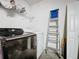 Laundry room featuring modern washer and dryer units, storage shelves, and white walls at 1364 Rebecca Dr, Haines City, FL 33844