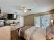 A comfortable main bedroom with wood flooring, ceiling fan, and access to a private patio at 1364 Rebecca Dr, Haines City, FL 33844
