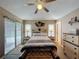 A comfortable main bedroom featuring wood flooring, a ceiling fan, and access to an outdoor pool at 1364 Rebecca Dr, Haines City, FL 33844